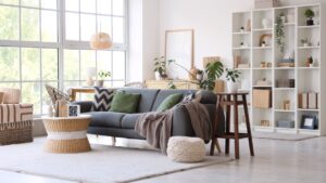 Interior of stylish modern living room with grey sofa, coffee table and shelving unit