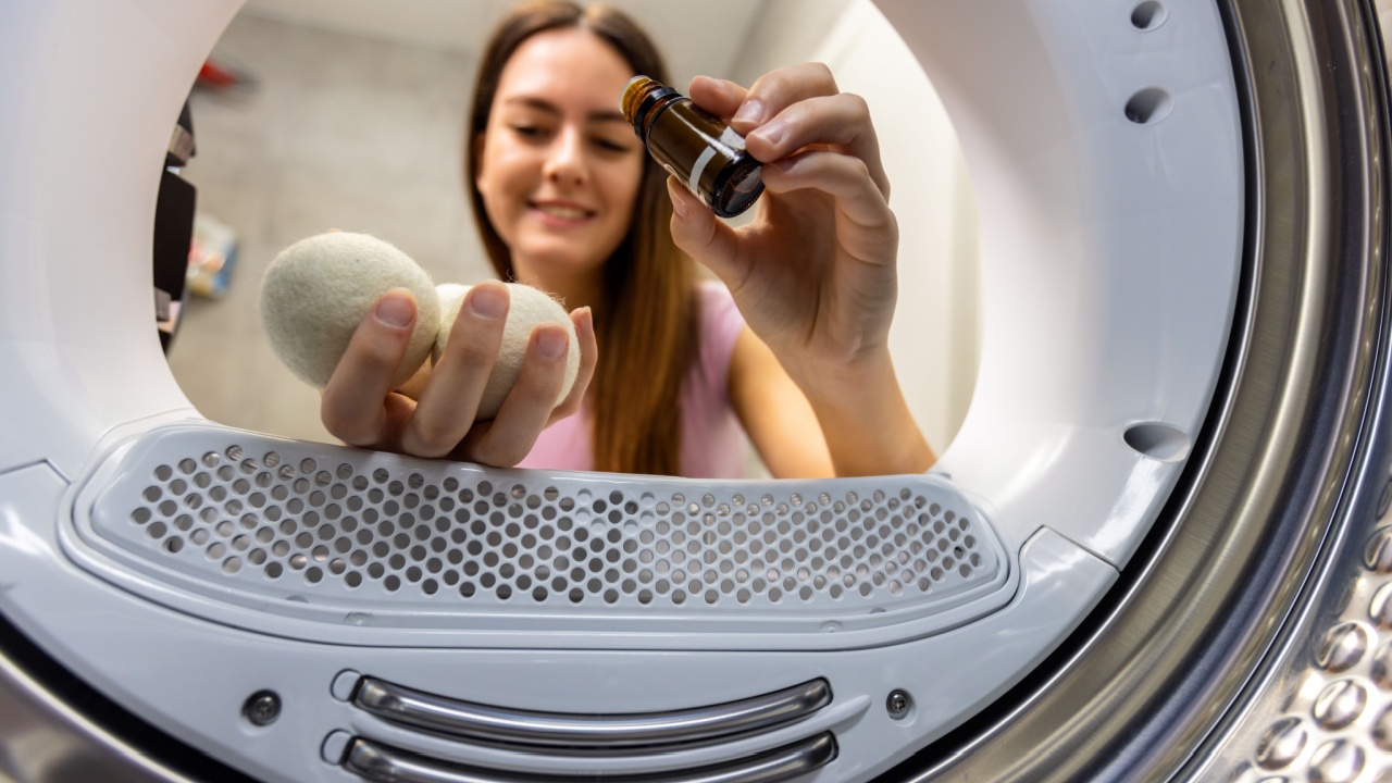 Wool drying balls for washing machine. Woman puts essential oil on the balls, for her towels to smell nice. View from the inside of the machine.
