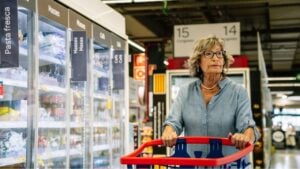Senior woman shopping groceries in supermarket aisle