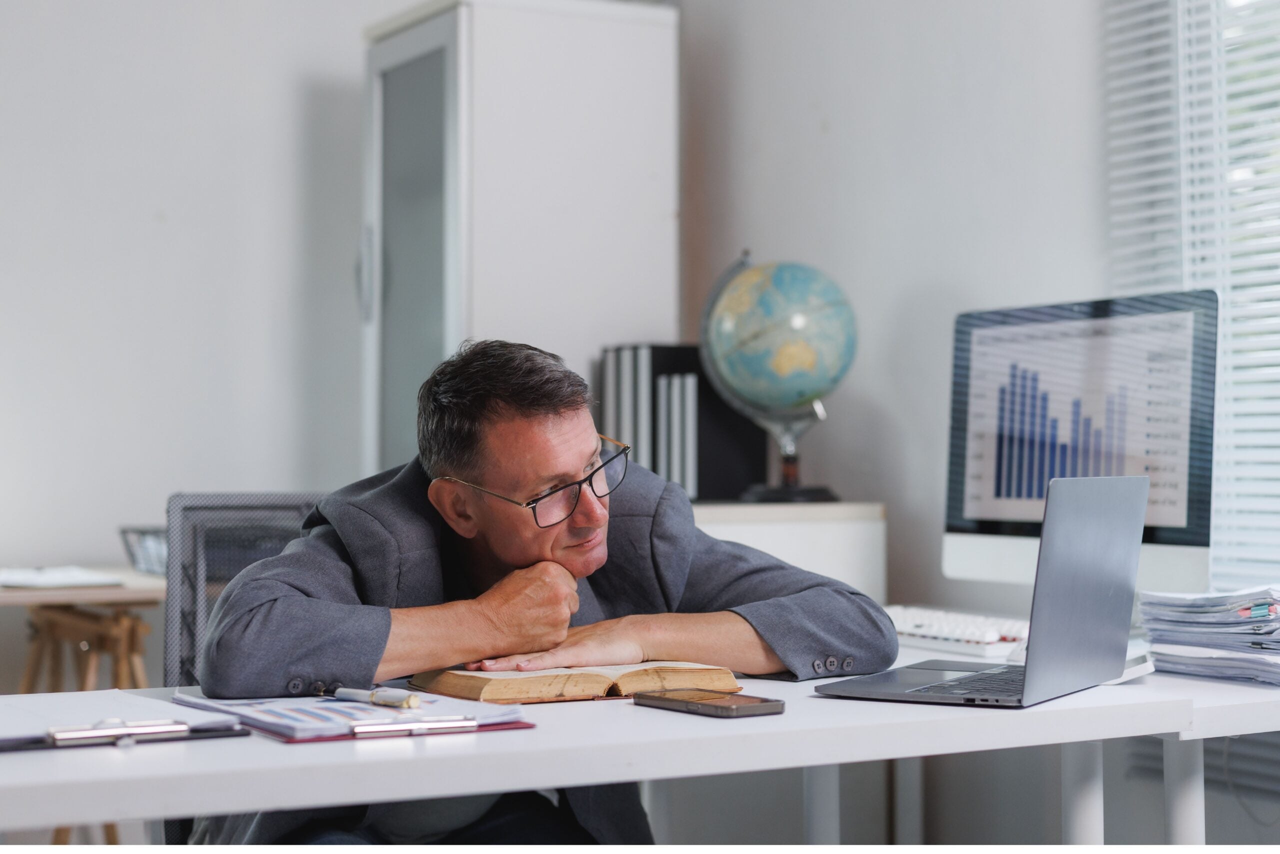 Man feeling exhausted and bored at his office desk, perhaps procrastinating work or resting from a long day