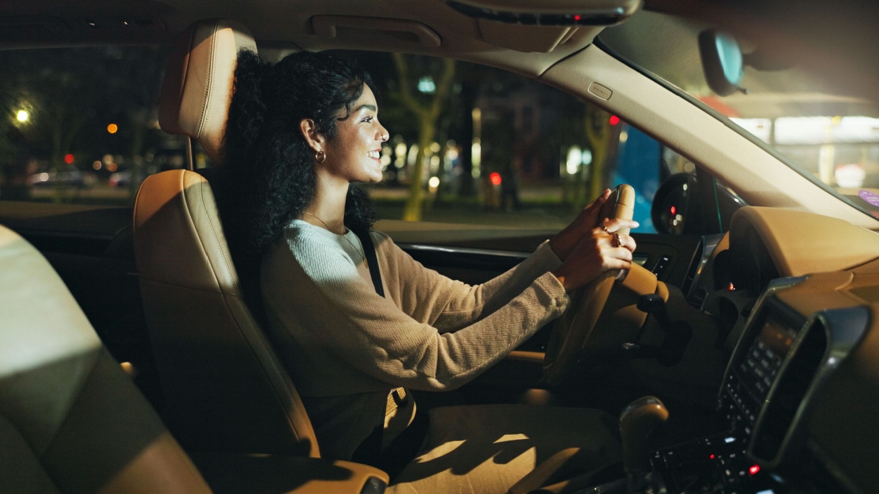 Business, night and travel with happy woman in car on city street for commute to destination. Drive, smile and transportation with employee in vehicle for journey or ride in dark urban location