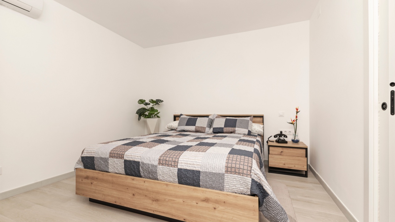 Side view of a bed with a green velvet upholstered headboard and a gray plush duvet, showcasing the plush texture and depth of the bedding set