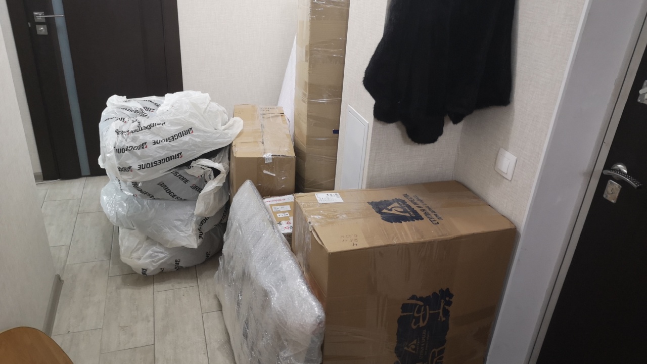 Samara, Russia - April 15 2020 - Cardboard boxes, wrapped items and plastic bags stacked in a home hallway during packing or moving.