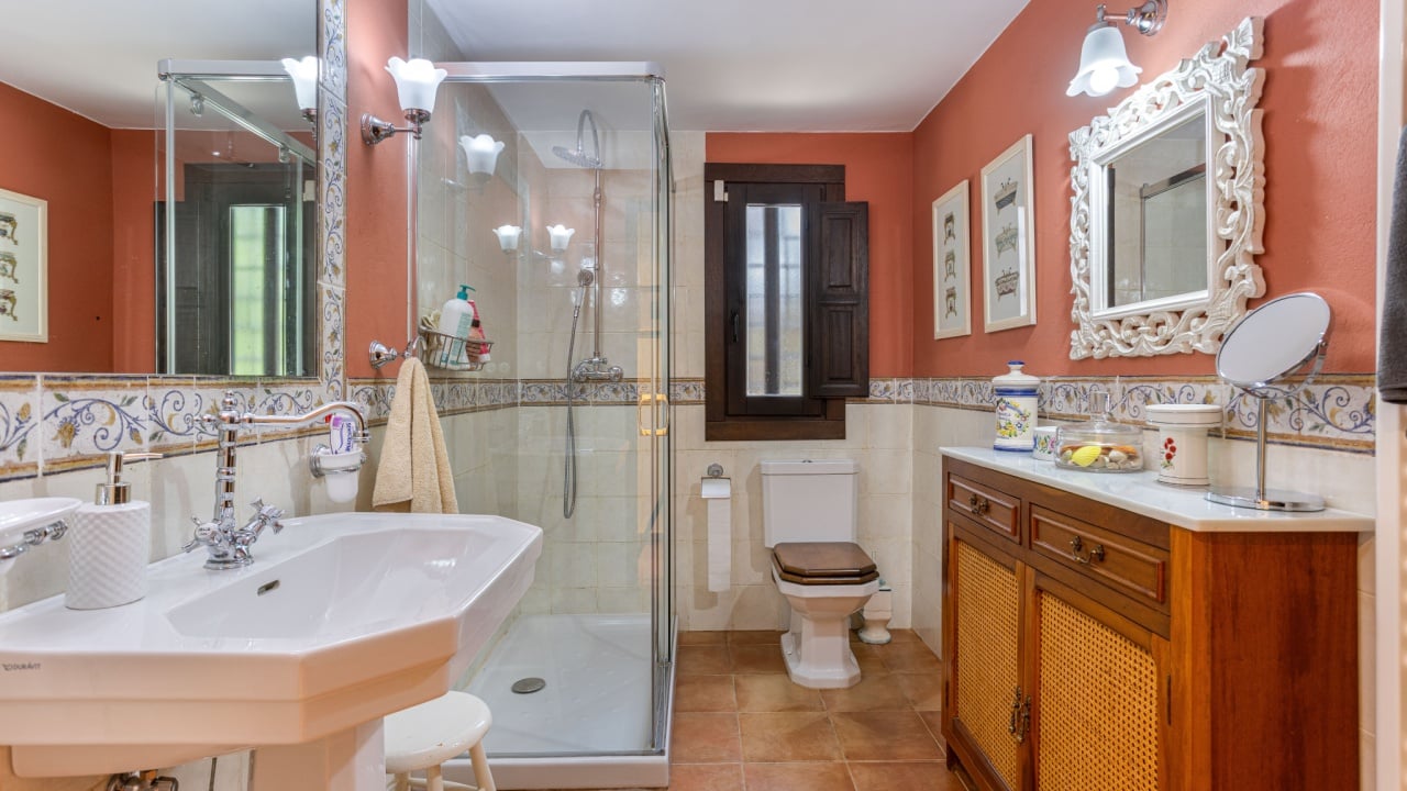 Torrevieja Spain 24 September 2025: Classic bathroom interior with glass shower, wood furnishings, ornate mirror, and floral tiles