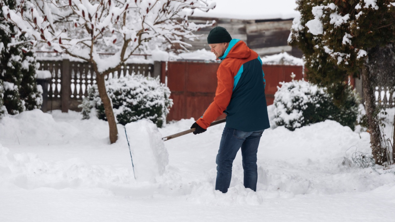 Man cleaning snow in the yard after heavy snowfall in winter