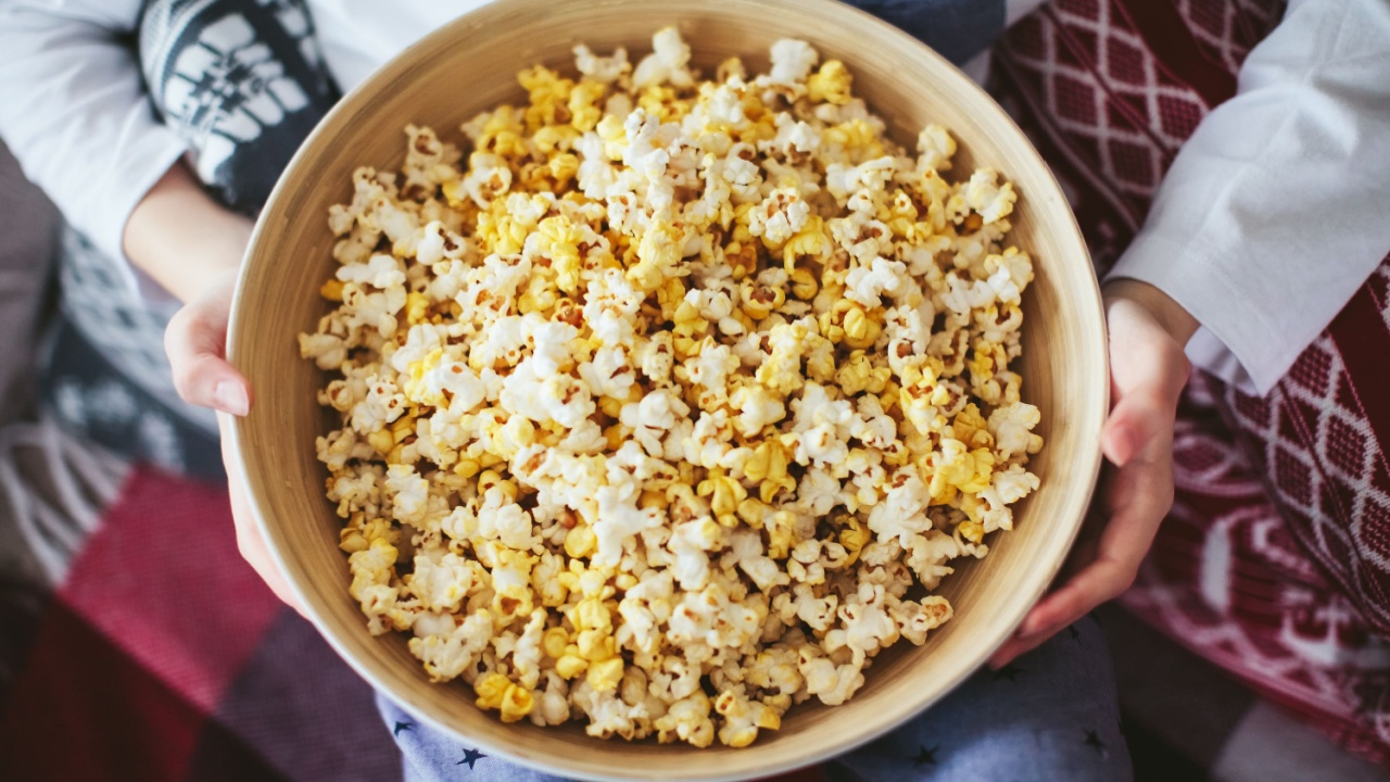 boy's hand holding a large bowl of popcorn