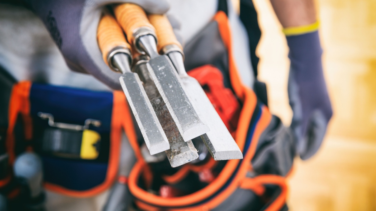 Worker with tool belt holding set of chisels