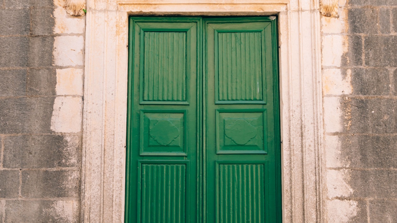 Green doors. Wood texture. Old shabby, irradiated paint. Old wooden doors