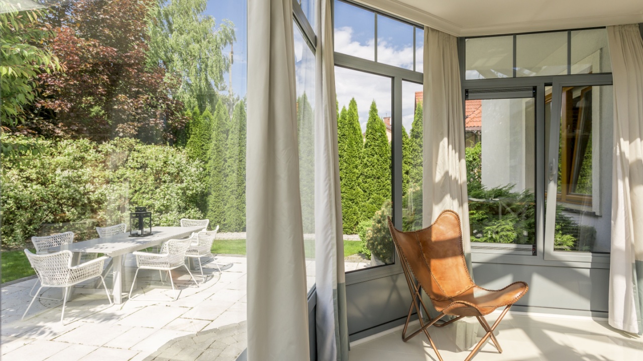 Minimalistic indoor orangeria with panoramic windows and garden view