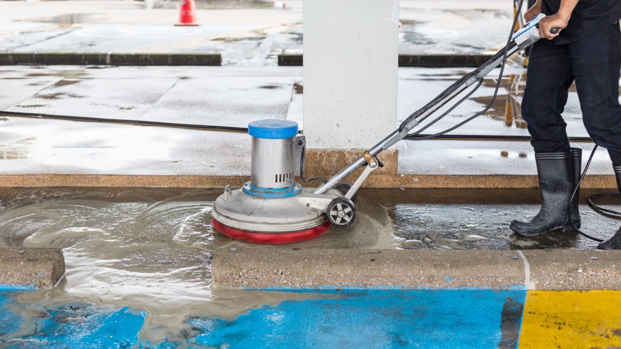 Asian worker cleaning sand wash exterior walkway using polishing machine and chemical or acid