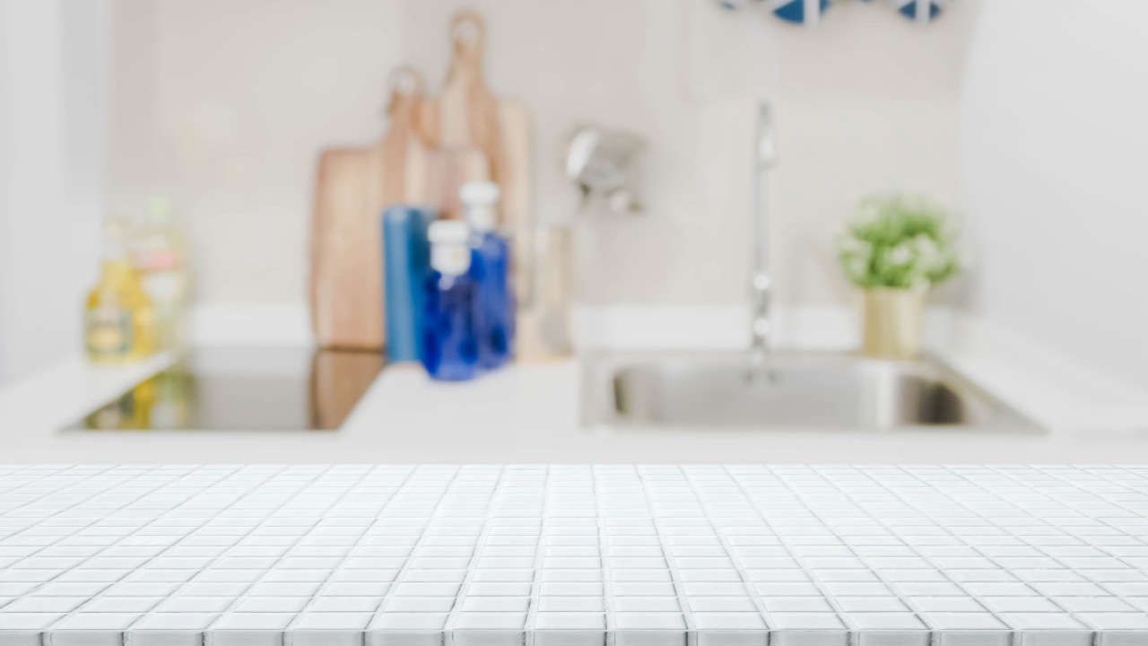 White ceramic mosaic tile table top and blurred kitchen interior background - can used for display or montage your products.