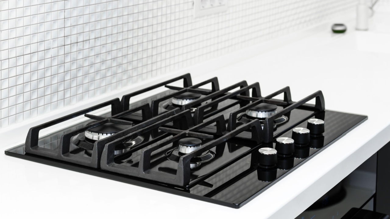 Gas stove with and embedded electric oven at brand new modern white kitchen