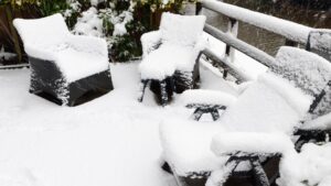 Backyard, garden plastic furniture under snow