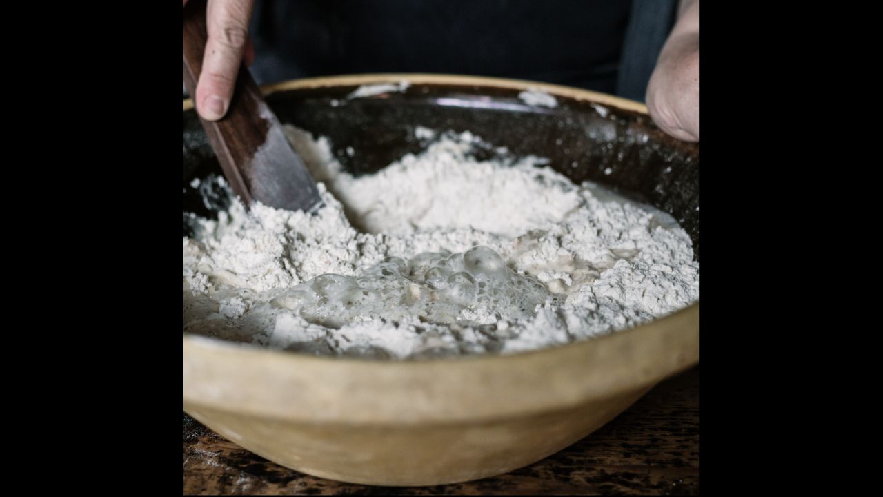 This photo was taken at The Sourdough School, and is of starter being mixed in to flour and water to make sourdough bread