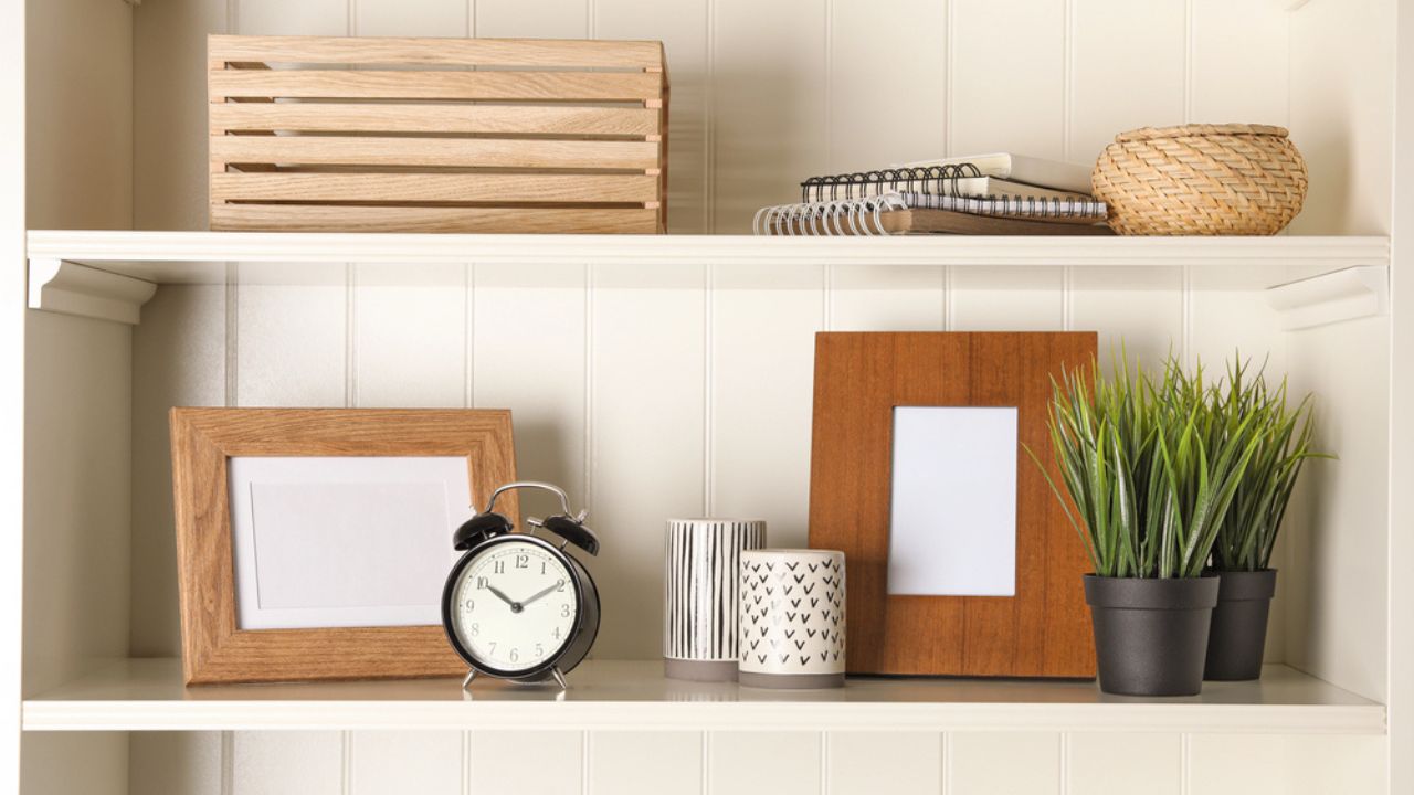 White shelving unit with photo frames and different decorative elements