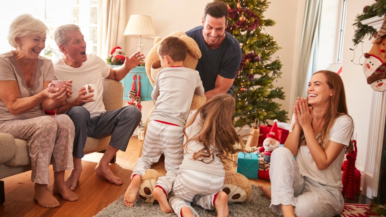 a family with three generations opens gifts on Christmas morning