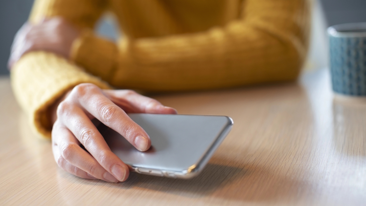a hand sets a smartphone down on a table