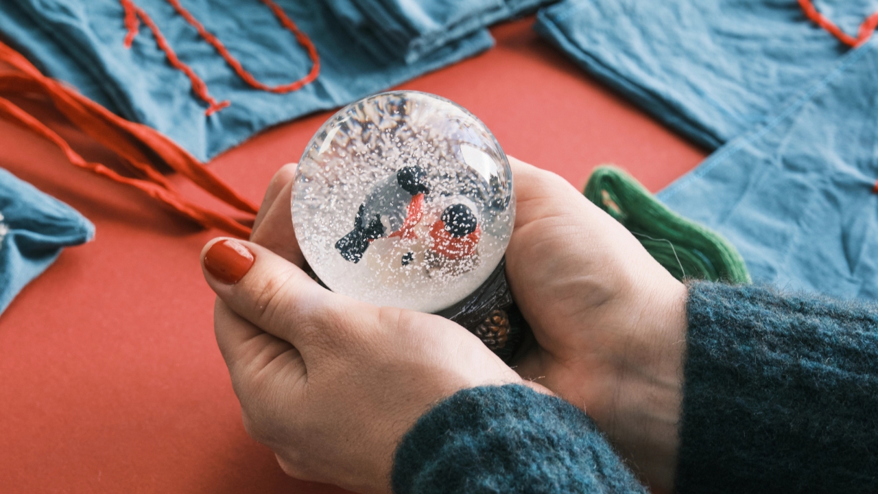 hands holding a small snow globe