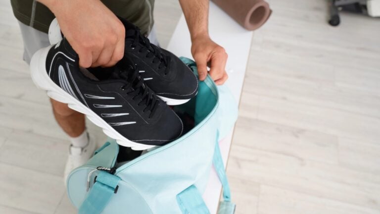 a man puts a pair of sneakers into a gym bag