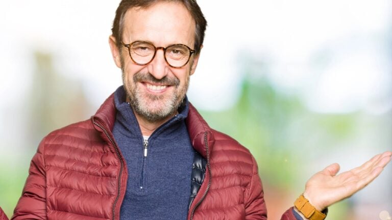 a man with glasses in a quarter zip sweater