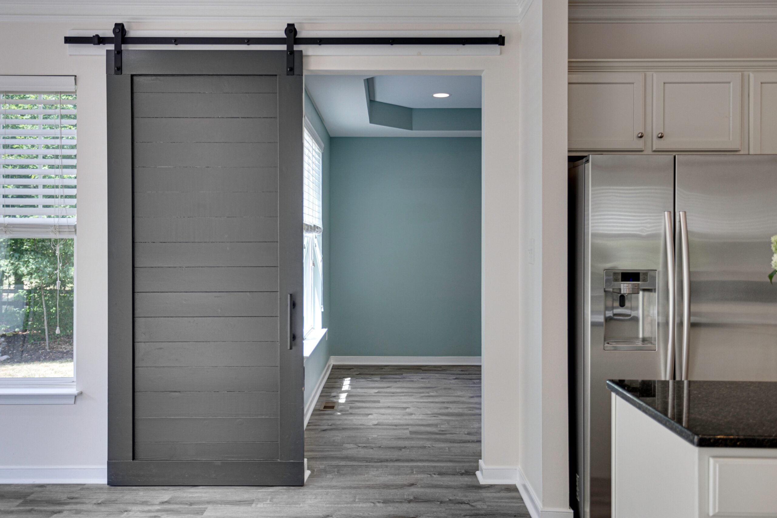 Modern Kitchen With Gray Barn Door And View Of Adjacent.