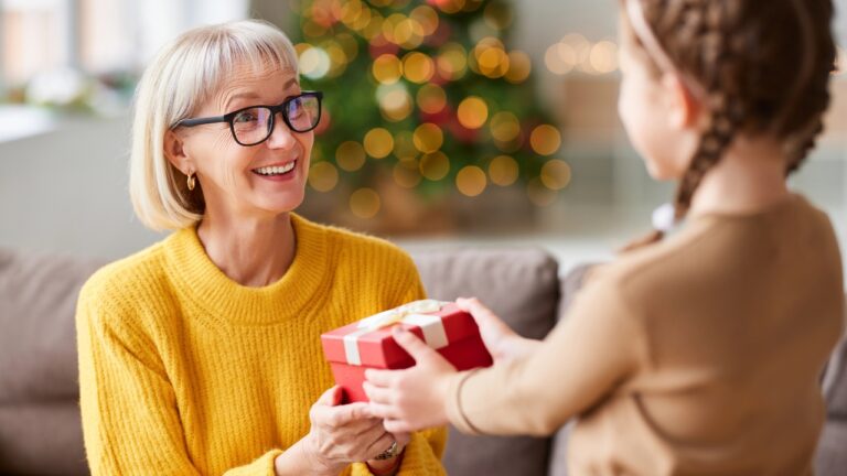 a middle-aged woman receives a Christmas gift from a little girl
