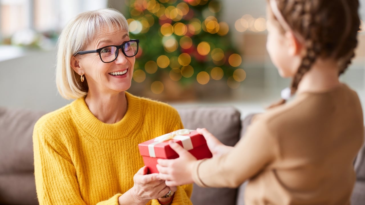 a middle-aged woman receives a Christmas gift from a little girl