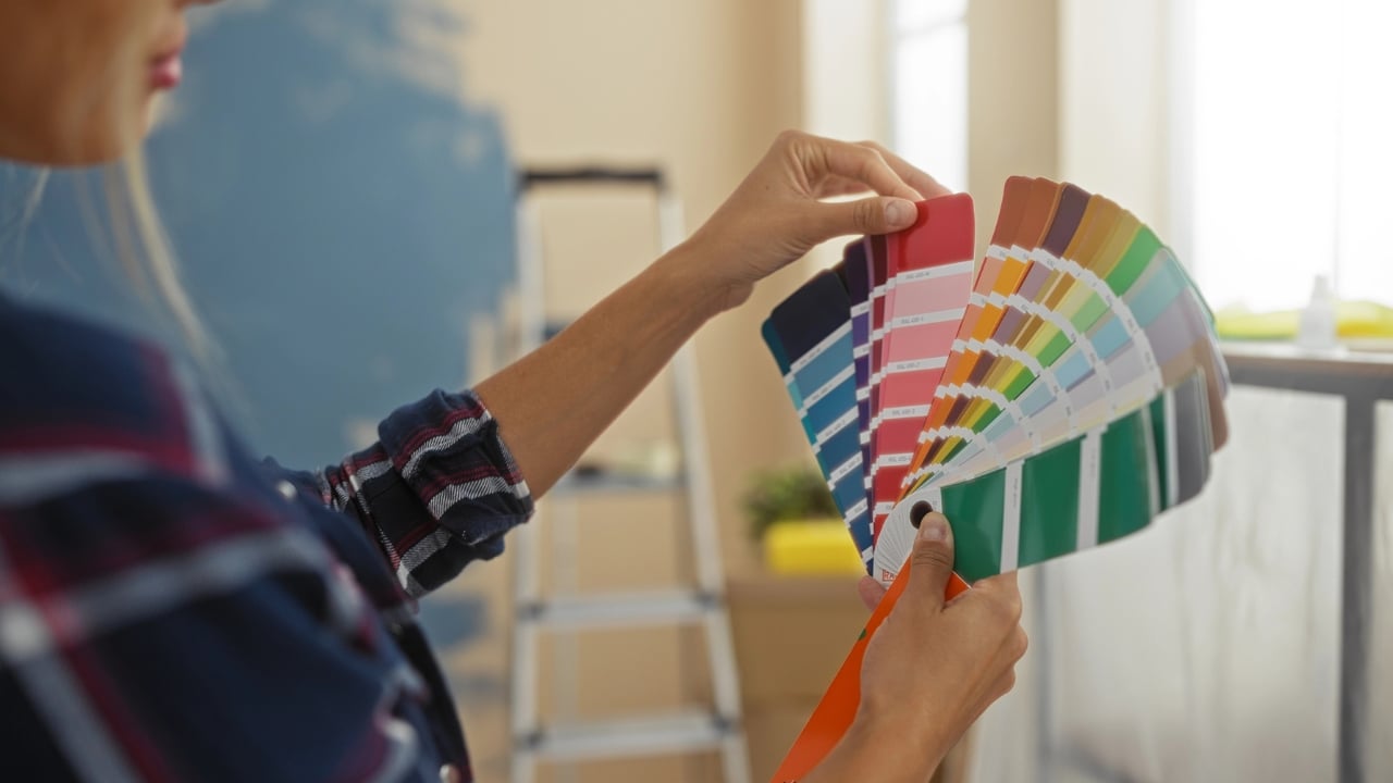 a woman holds a stack of paint chips