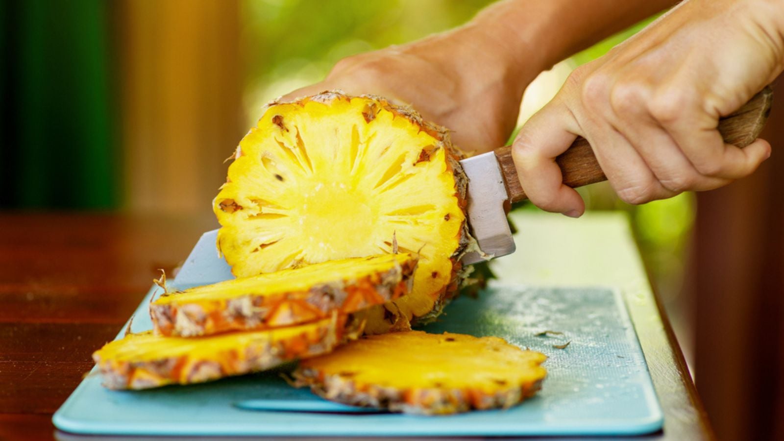 Closeup of knife and slices of fresh ripe pineapple