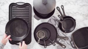 Flat lay. Variety of cast iron kitchenware on a marble countertop