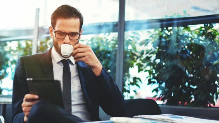 Concentrated male freelancer searching information for creating and programming new website for company order, reading news about internet provider via laptop