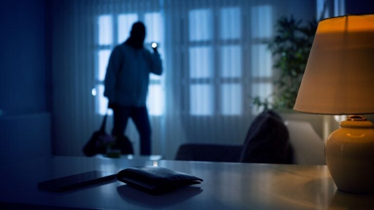 Burglar or intruder inside of a house or office with flashlight