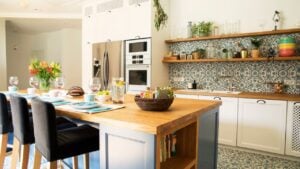 Fresh summer breakfast in Mediterranean style kitchen. Bright and sunny space with a lot of herbs and plants. Modern kitchen with open space shelves
