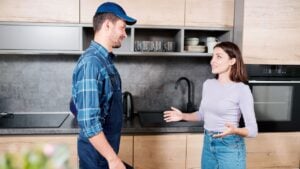 Young housewife consulting with technician of household maintenance service