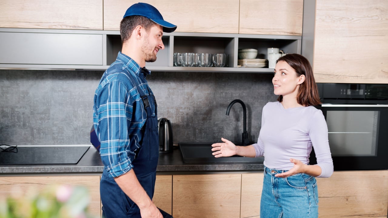 Young housewife consulting with technician of household maintenance service