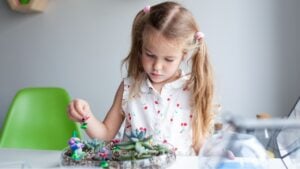 Beautiful girl plants succulents in a glass florarium at a lesson in a creativity studio