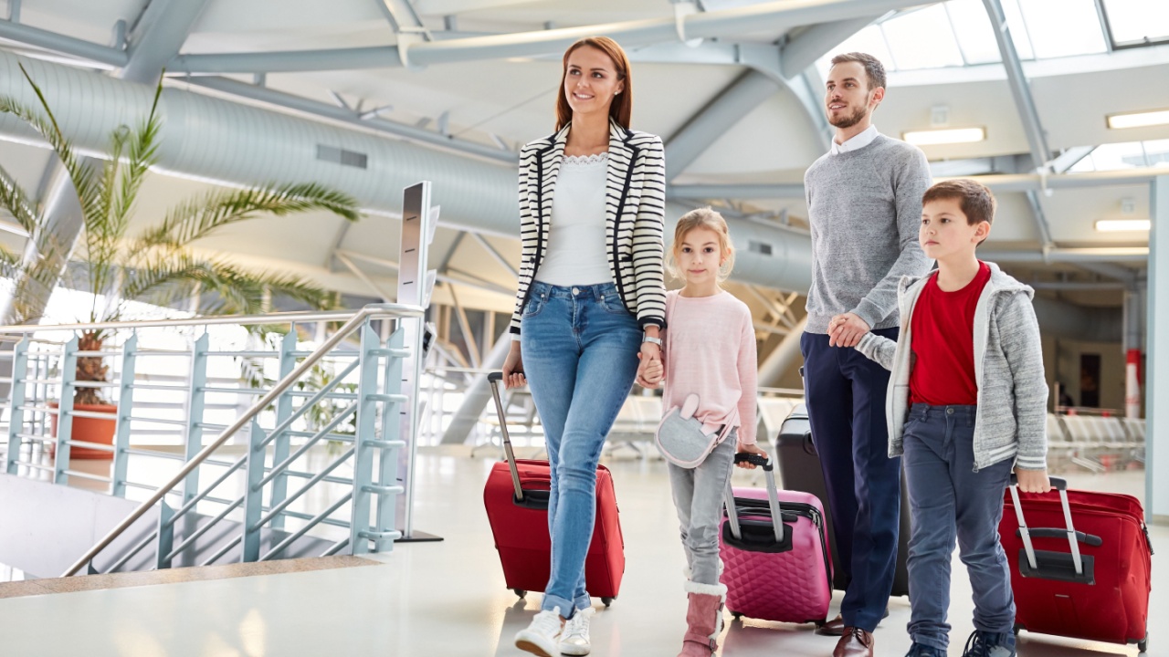 Family with children and luggage on the road on vacation in the airport terminal