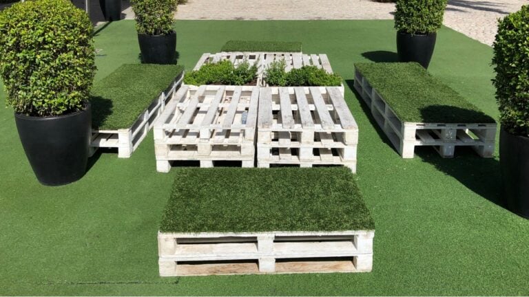 Wooden decor, pallet furniture, green plants and artificial lawn on a street city, urban space