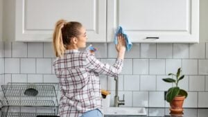 Female washes cleaning kitchen set with rag or cloth. House professional cleaning service.