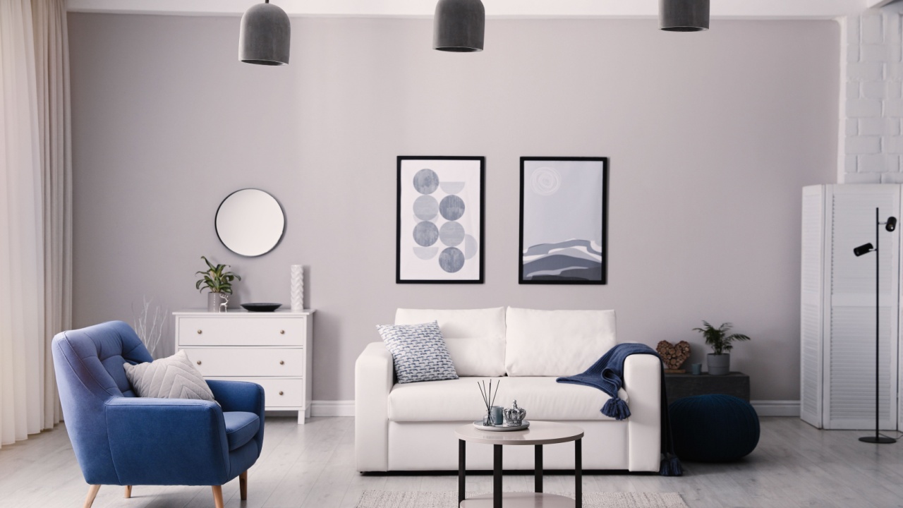 Stylish living room interior with white sofa, armchair and small coffee table