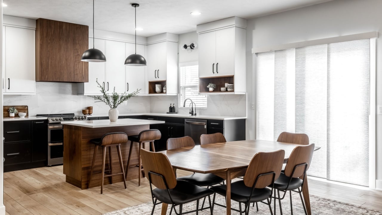 OMAHA NE USA - 02-01-2022 - Midcentury modern kitchen and dining room interior design with black cabinets, white cabinets, white quartz and walnut accents