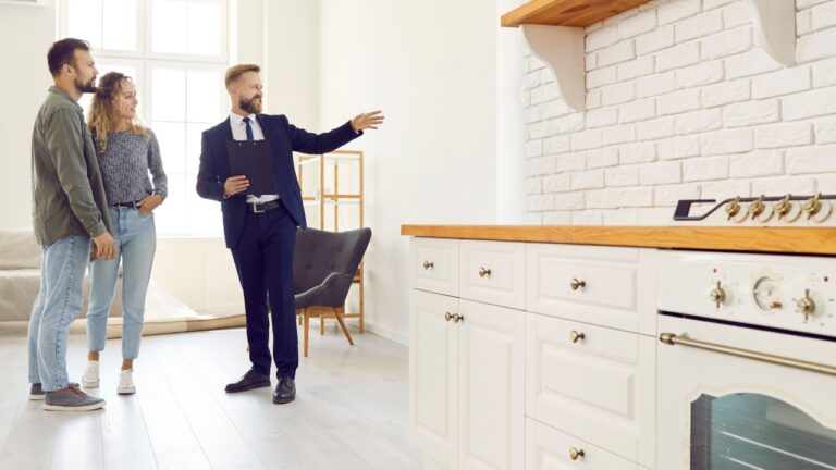 Male realtor or broker show home to couple buyers or renters buying