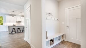 Laundry room mud room entry area with bench seat and coat hangers washing and drying machine