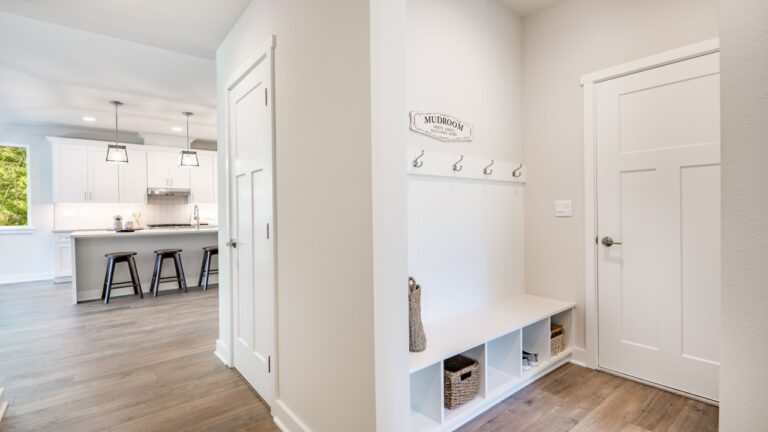 Laundry room mud room entry area with bench seat and coat hangers washing and drying machine