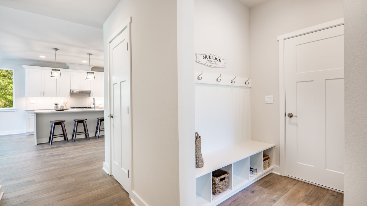Laundry room mud room entry area with bench seat and coat hangers washing and drying machine
