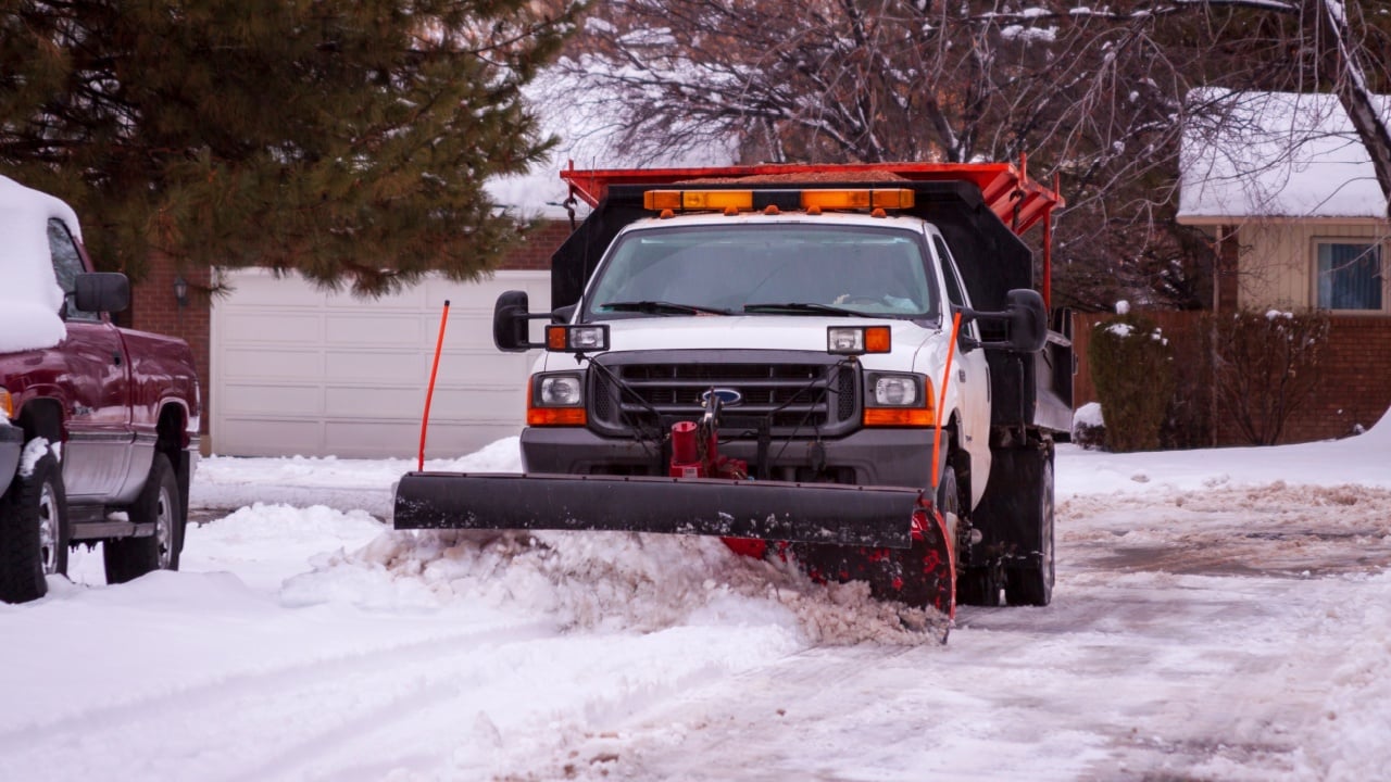 Snowplow plowing a residential street