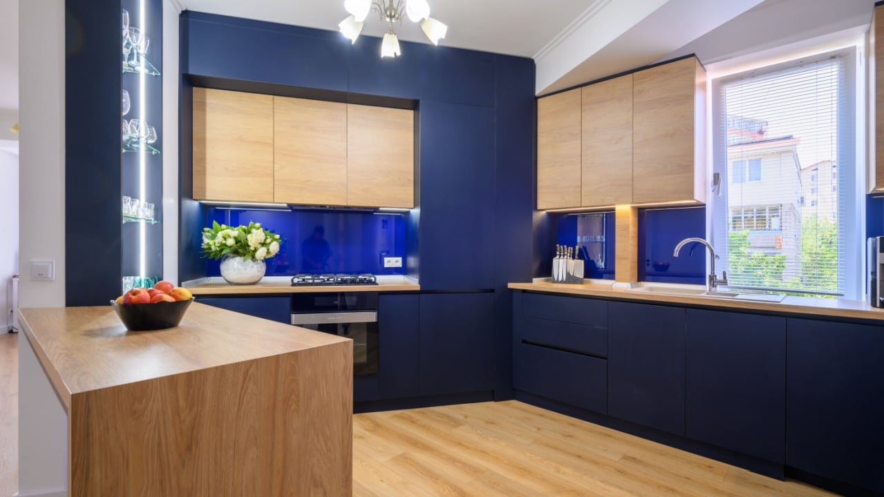 Stylish large studio apartment with kitchen open to living room after good renovation, closeup to counter blue and wood