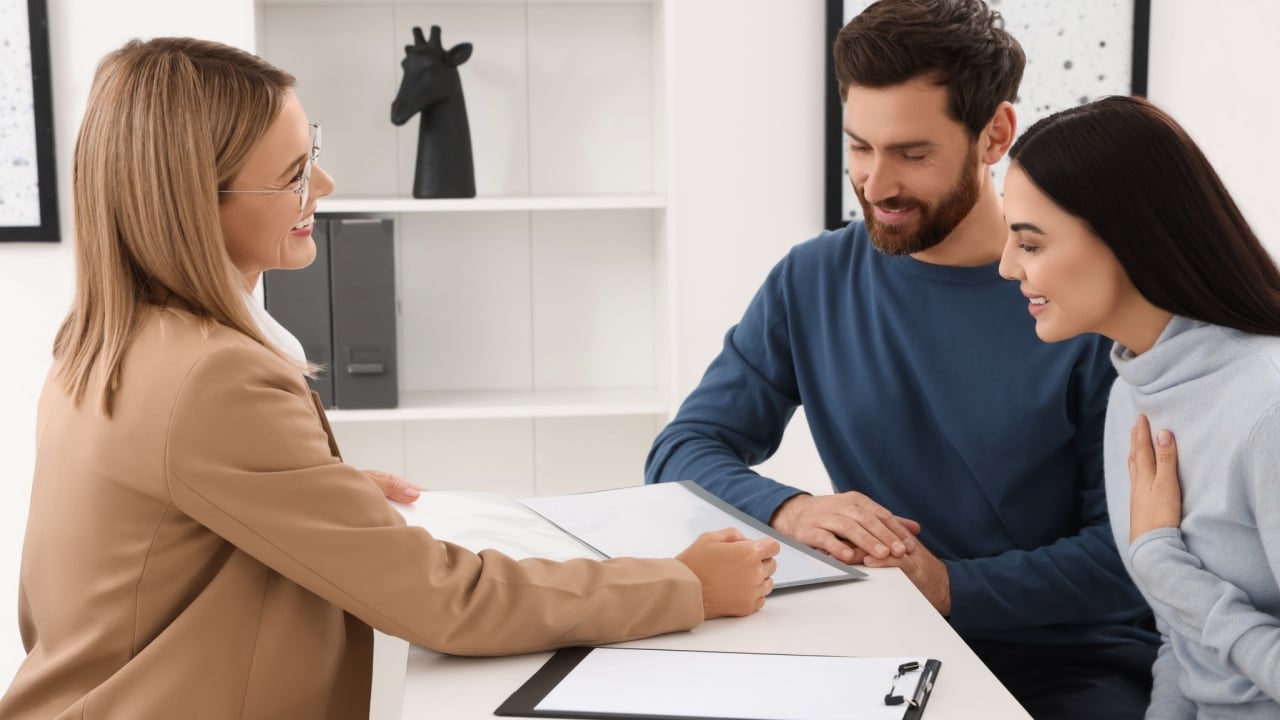 Real estate agent working with couple in office
