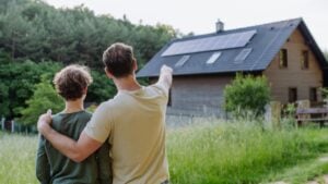 Father showing roof with solar panels to his son. Alternative energy, saving resources and sustainable lifestyle concept.