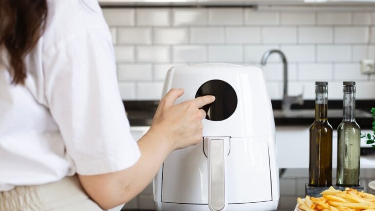 Woman cooking with modern Air fryer